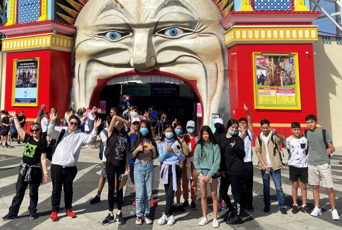 A group of young people standing in front of luna park