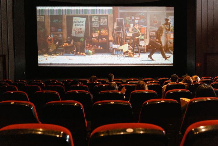 image of seats in a cinema with a cartoon movie playing on a large screen in colour