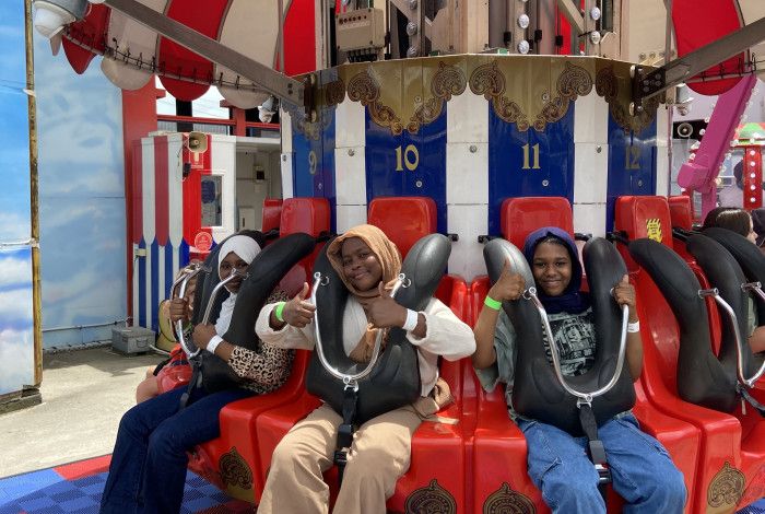 Young people smiling on a ride at Luna Park