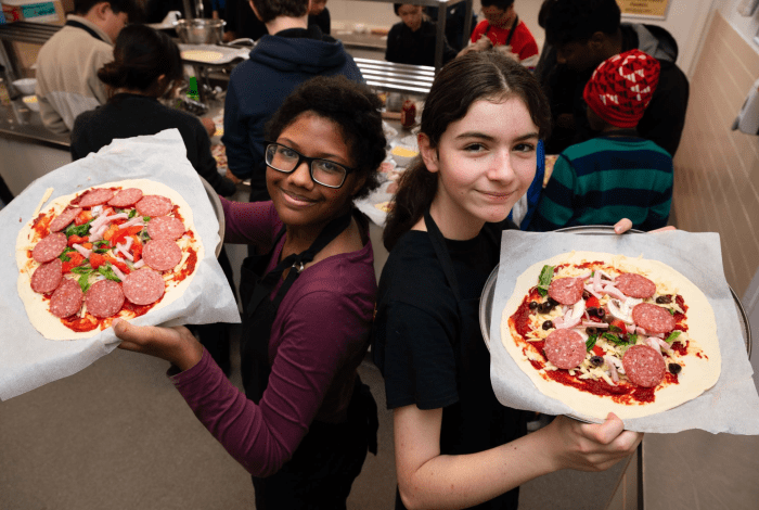 Two young people with pizzas