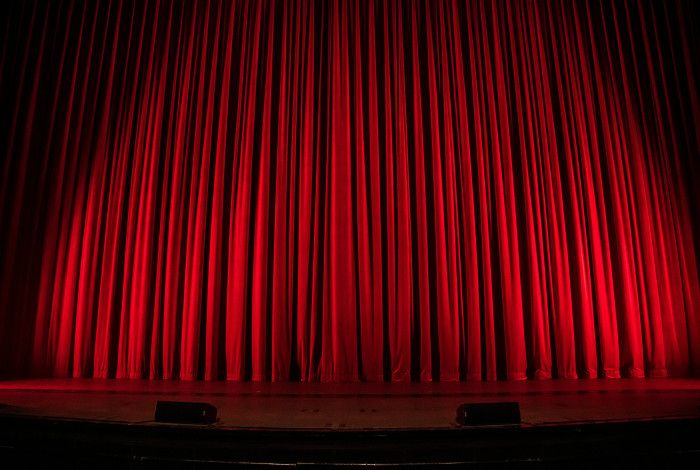 Image of a red theatre curtain. 