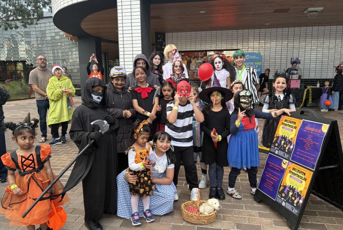 Image of a group of young people posing for a photo in Halloween costumes.