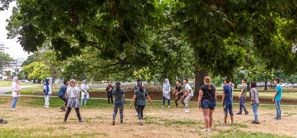 Young people playing under tree