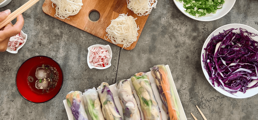 An image of Rice Paper Rolls with various fresh ingredients in bowls like noodles, purple cabbage and Spring onion