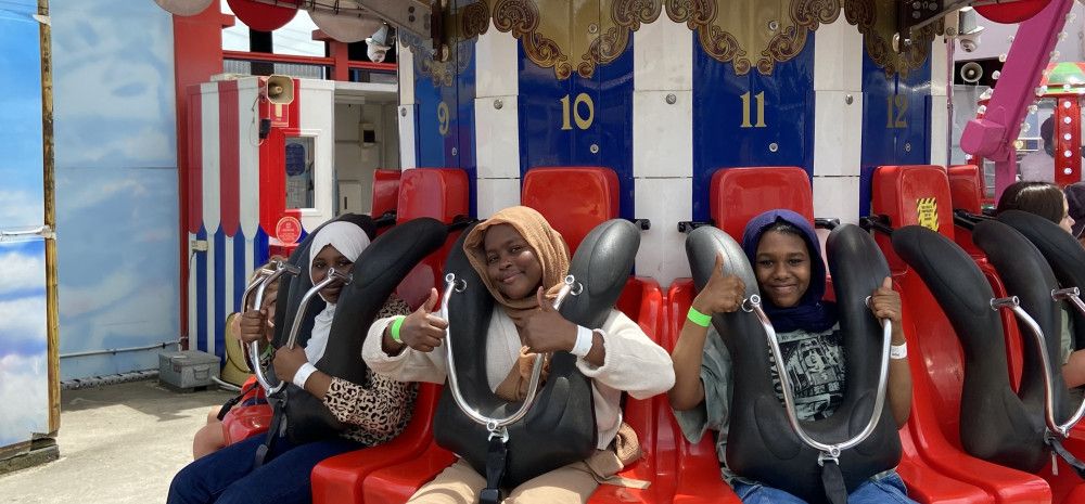 Young people smiling on a ride at Luna Park