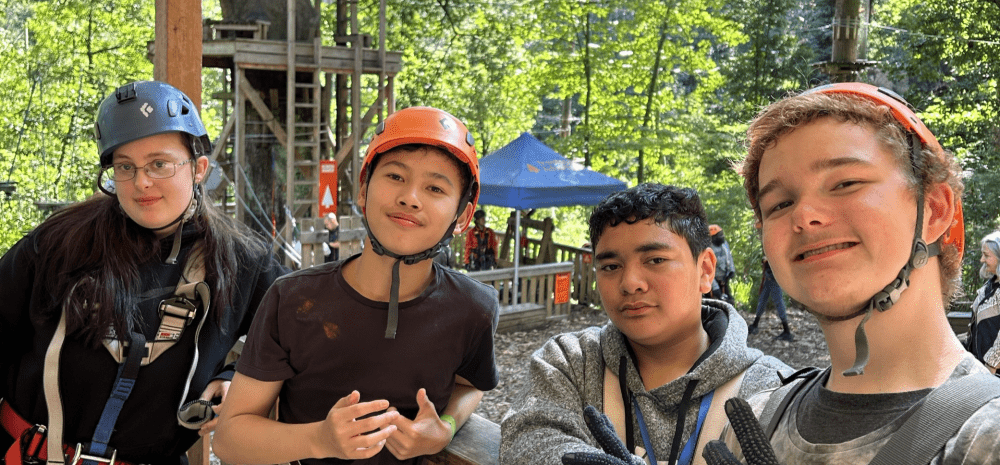 young people smiling at treetops