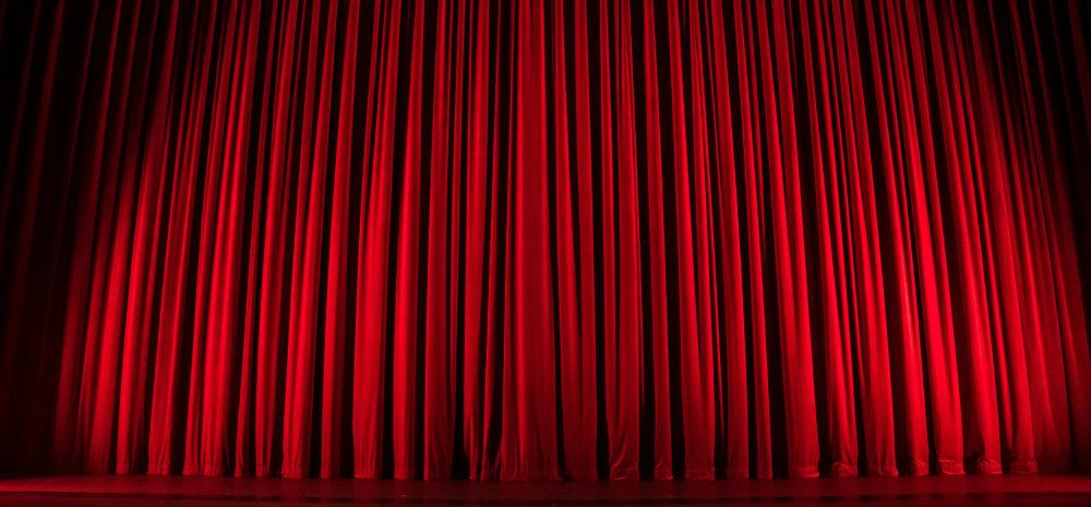 Image of a red theatre curtain. 